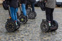 Eine Gruppe auf Segways in der Stadt unterwegs.